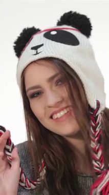 Bu canlı portre neşe saçan genç bir kızın neşeli bir panda şapkası taktığını gösteriyor. İfade dolu yüzü ve tasasız duruşu parlak beyaz bir arka plana karşı gençlik enerjisi ve çekiciliği yayarak izleyicileri paylaşmaya davet ediyor.