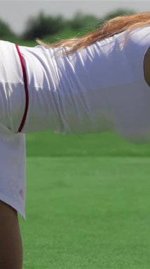 Büyüleyici bir yan bakış, dört ayak üzerinde duran kızıl saçlı çarpıcı bir golfçüyü yakalar ve deliğe odaklanır ve vurmaya hazırlanır. Pürüzsüz beyaz bir etek ve üzerine de bir tişört giymiş olan bu beyaz atletik kadın yaz sporu enerjisi yayıyor.