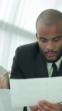 Aralarında bir kadının da bulunduğu dört kendinden emin işadamından oluşan bir grup, parlak, güneşli bir ofiste belgeleri incelerken tutkulu bir şekilde stratejileri tartışıyor. Animasyon ifadeleri ve işbirlikçi jestleri ekip çalışmasının canlı bir atmosferini yayıyor.