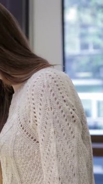 Uzun saçlı, genç ve çekici bir kadın, büyüleyici bir kahve dükkanındaki lezzetli pastalar ve pastalardan birini seçiyor. O, lezzetli seçeneklerini düşünürken, davetkar atmosfer fırınlanmış yiyeceklerin tatlı aromasıyla doludur.