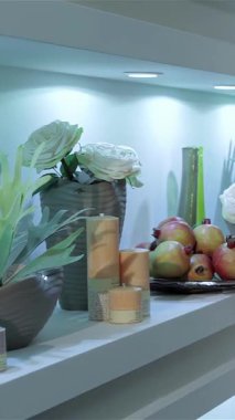 Çiçekçi dükkanında gezen iki şık kadın büyüleyici çiçeklerden büyülenmişler. Şık mavi bir bluz giyen zarif çiçekçi, dalgalı saçlı neşeli arkadaşına nefes kesen beyaz bir çiçek sergiliyor.