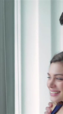 Neşeli bir çift pencerenin kenarında durur, taşınan kutularla çevrili, yeni yolculuklarına çıkarken sevgi ve heyecan saçan bir çift. Gülüşleri, sonsuz boş bir dairede yeni bir başlangıç yapmanın mutluluğunu yansıtıyor.