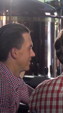 Sıcak bir gülümsemesi olan çekici bir barmen hayat dolu bir barda iki memnun müşteriye ferahlatıcı el yapımı bira doldurur. Kahkaha ve arkadaşlıkla dolu davetkar atmosfer hafta sonu rahatlığının ve sosyal zevkin özünü yakalıyor.