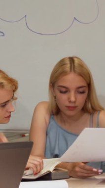 Yakışıklı bir genç erkek öğrenci ve onun gülümseyen bayan arkadaşı parlak bir kampüs kütüphanesinde odaklanmış sınıf arkadaşları tarafından laptopları üzerinde çalışırken canlı bir tartışmaya girişirler. Bu canlı sahne takım çalışmasının ve akademik çalışmanın özünü yansıtıyor.