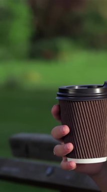 Parlayan hamile bir kadının, parkta otururken çayını yudumlarken, sıcaklık ve beklenti saçtığı yakın plan bir fotoğraf. Sahne, anne olmanın özünü ve yemyeşil yemyeşil ve yumuşak güneş ışığıyla çevrili yeni bir hayat beklemenin neşesini yakalıyor.