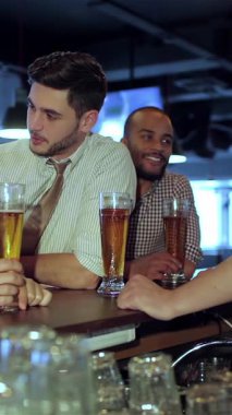 Dört genç iş adamı, enerji dolu, neşeli ve kahkahalar atan bir barda biralarının keyfini çıkarırken. Heyecanlı bir atmosfer var. Televizyonda tutkulu bir şekilde futbol izliyorlar. Arkadaşlıklarını ve kutlamalarını kutluyorlar.