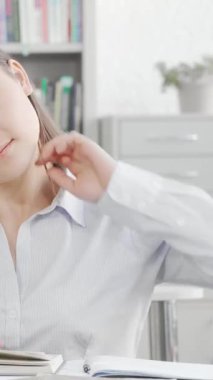 Güzel bir Asyalı kadın, serin bir kütüphanede kitap yığınlarıyla çevrili sırtını germek için biraz zaman harcar. Bu sahne, yaklaşan sınavlarına kararlılıkla hazırlanırken kendini adamanın ve bilgi arayışının özünü yakalıyor.