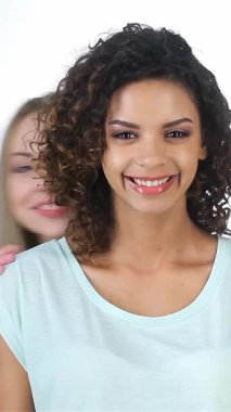 Asyalı, Afrikalı ve Kafkas kökenli üç canlı genç kadın bir neşe anını paylaşıyor. Katlanmış bir perdenin arkasından bakıp şakalaşarak gülüyor ve fısıldıyorlar. Işıl ışıl gülüşleri ve anlamlı duyguları,