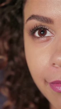 Neşeli genç bir kızın yakın plan portresi, büyüleyici bir film izlemenin heyecanını yansıtan ışıl ışıl gülüşü. Parlak gözleri ve kıvırcık saçları sinemanın heyecanını temsil ediyor. Kahkahalarla dolu bir tiyatronun samimi atmosferiyle çevrili.