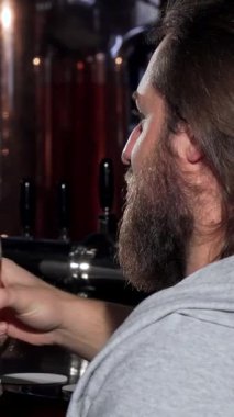 İki genç adam, buzlu bardaklarını altın zanaat birasıyla doldurarak keyifle tokuşturuyor, sıcak bir barın tadını çıkarıyorlar. Hayat dolu atmosfer kahkaha ve arkadaşlıkla dolu, dostluğu ve hayatın hoş anlarını kutluyoruz.