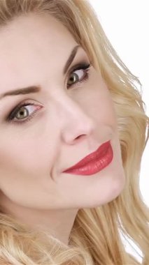 Çekici sarışın bir kadın zarif bir şekilde yüzüne dokunuyor ve saf beyaz bir arka planda doğal güzelliğini sergiliyor. Bu portre baharın özünü yakalıyor, bir çiçek çelengi ile zarafetini ve cazibesini arttırıyor, ona hayranlık uyandırıyor.