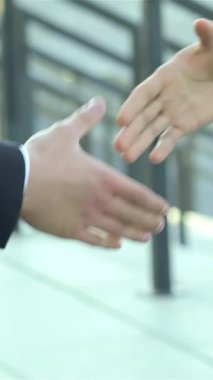 İki elin yakın çekimi, bir karanlık ve bir aydınlık, dinamik bir el sıkışma, hareketli bir şehir caddesinde canlı bir ortaklığı sembolize ediyor. Sahne heyecan ve fırsat saçıyor, keskin iş kıyafetleri içindeki bu gülümseyen profesyoneller...