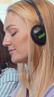 Gösterişli kulaklıklarla donatılmış genç profesyonellerden oluşan canlı bir ekip, parlak, modern bir çağrı merkezinde canlı tartışmalara dalıyor. Kadın teknik destek operatörünün ışıl ışıl gülümsemesi ve hevesli meslektaşları canlandırıcı bir şey yaratıyor.