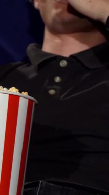 Büyük bir kova patlamış mısırı paylaşan bir kadın ve erkeğin heyecanlı bir film galasının tadını çıkarırken gözleri heyecanla parlarken çekilen hoş bir sahne. Sıcak atmosfer sıcaklık ve samimiyet saçıyor. Bu geceyi unutulmaz kılıyor.