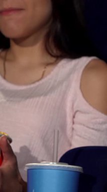 Sıcak bir sinema ortamında, bir erkek ve bir kadın büyük bir kova patlamış mısırı neşeyle paylaşırlar, heyecanlı bir film galasının tadını çıkarırlarken gözleri heyecanla parlar. Samimi atmosfer sıcaklık ve bağlılık saçıyor, bu randevu gecesini...