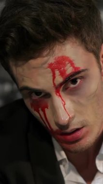 Büyüleyici bir vampir adam, yüzü çarpıcı bir şekilde dramatik kan çizgileriyle boyanmış, gözleri gölgeli bir tuğla zemine kenetlenmiş. Bu ürpertici portre Cadılar Bayramı 'nın özünü yakalıyor. Büyüleyici bir görüntüde cazibe ve korkuyu harmanlıyor.