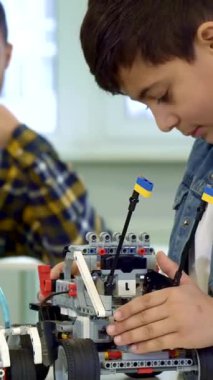 Koyu renk saçlı odaklanmış genç bir çocuk renkli bir oyuncak arabayı özenle birleştirirken, destekleyici Afrikalı Amerikalı babası da hafifçe aydınlatılmış odada gururlu bir gülümsemeyle izliyor. Bu iç açıcı sahne yaratıcılığın ve yaratıcılığın neşesini güzel bir şekilde gösteriyor.