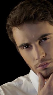 Gıcır gıcır beyaz gömlekli ve parlak siyah kravatlı yakışıklı genç beyaz bir adamın çarpıcı portresi dramatik bir siyah arka plana karşı derin bir tefekkür içinde tıraşsız çenesini okşuyor. Onun yoğun bakışları ve şık görünüşü kendine güven ve