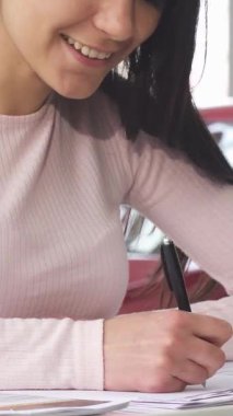 Yumuşak pembe kazaklı ışıldayan bir kadın parlak, parlak araçlarla çevrili canlı bir galeride rüya arabasının son evraklarını zevkle imzalıyor. Bu heyecan verici an, sahipliğin heyecanını ve yeni maceraların vaadini özetliyor.