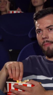 Bakımlı sakallı yakışıklı genç bir adam loş bir sinemada oturup patlamış mısır yerken sıkılmış ifadesi sıkıcı filmle ilgili hayal kırıklığını gözler önüne seriyor. Farklı dinleyiciler tarafından çevrelenmiş ortamda,