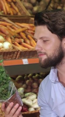 Genç, modaya uygun sakallı, beyaz bir adam renkli bir dizi taze ürünle çevrelenmiş fesleğen kokulu bir demet fesleğeni tepsiye koyar. Zevkli ifadesi aşçılık tutkusunun özünü yansıtıyor. Kendini zengin bir aşçıya kaptırıyor.