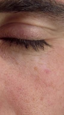 Yakından bakınca bir adamın neşeli ifadesini yakalıyor. Çarpıcı yeşil gözleri mutluluk ve güvenle parıldıyor. Yumuşak ışık onun özelliklerini ön plana çıkarıyor, izleyicileri bir bağlantı ve iyimserlik hissiyle çeken davetkar bir atmosfer yaratıyor.