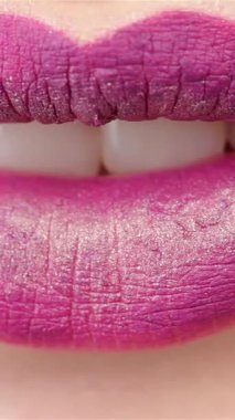 Bu büyüleyici makro çekim baştan çıkarıcı bir dişinin ağzını yakalıyor, hafifçe ayrılmış, parlak beyaz dişler sergiliyor sulu, pırıl pırıl erik dudaklar arasında. Işıl ışıl sarı bir zemin üzerine kurulmuş bu görüntü cazibe ve cazibe yayıyor.