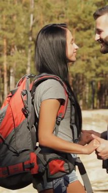 Neşeli bir Kafkas çifti, canlı yeşillikler ve yükselen ağaçlarla çevrili, çarpıcı bir uçurumun kenarında samimi bir kucaklaşmayı paylaşıyor. Şortlu güzel esmer kadın, sakallı erkek arkadaşına sarılıyor. O da sevgiyle burnunu öpüyor.