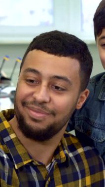 Gururlu bir Afrikalı Amerikalı baba ve tapılası oğlu hoş bir masada neşeli bir selfie anı paylaşıyorlar. Etrafı oyuncaklarla çevrili. Baba, şık bir ekose gömlek giyiyor, küçük oğlu gibi mutlulukla ışıldıyor, şık bir kot ceket giyiyor.