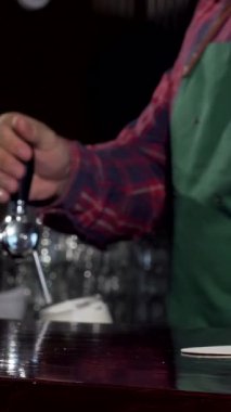 Yetenekli bir barmen bardağa altın gibi köpüklü bir bira doldurur, kahkaha ve arkadaşlıkla dolu canlı bir bar atmosferinin özünü yakalar. Cilalı tezgah, çevrenin sıcaklığını yansıtır. Müşterileri eğlenmeye davet eder.