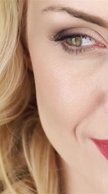 Güzel bir kadının büyüleyici yakın çekimi dalgalı sarı saçlarıyla narin çiçeklerin arasında nazikçe yüzünü okşuyor. Bu büyüleyici portre, baharın özünü yansıtıyor. Neşeli gülümsemesini ve zarafetini vurguluyor.