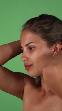 Genç bir kadının çarpıcı portresi zarif bir şekilde uzun, ipeksi saçlarını parlak yeşil renkli bir arka plana doğru çeviriyor. Bu büyüleyici sahne kendine güveni ve cazibesi yayıyor. Işıl ışıl ten renginin altını çiziyor ve yeni, sağlıklı bir vücut buluyor.