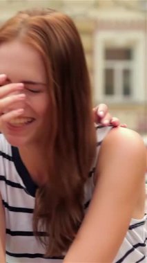 Birinde uzun kahverengi saçlı, diğerinde dalgalı siyah bukleli iki hayat dolu genç kadın, keyifli bir alışveriş çılgınlığından sonra arkadaşlığın ruhunu somutlaştıran, güneşten sırılsıklam olmuş bir bankta kahkahalara boğuldu. Bulaşıcı gülüşleri ve şakacı maskaralıkları