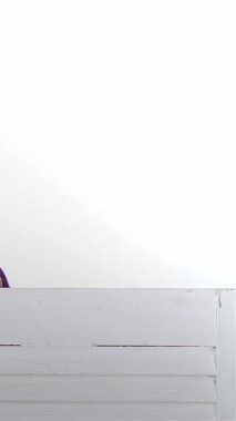 Üç neşeli kız, mutluluk saçan, şık bir perdenin arkasından dışarı bakan, parlak beyaz bir arka plana bakan. Bu canlı sahne, Asyalı, Kafkasyalı ve Afro-Amerikalı 'yı gösteren dostluğun ve çok kültürlülüğün özünü yansıtıyor.