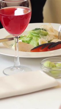 Canlı bir iş yemeği taze bir salata ve köpüklü bir bardak meyve suyu eşliğinde neşeli bir iş kadını ve erkek animasyon sohbetine girişir. Şık bir teras arkaplanına dayanan bu sahne profesyonel arkadaşlığa ışık saçıyor.