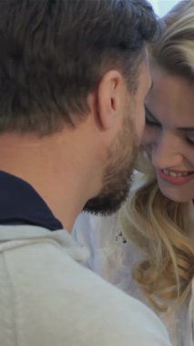 Çekici esmer bir adam ve onun çarpıcı sarışın karısı evde hassas bir anı paylaşıyorlar, alınları mutlu bir kucaklaşmayla nazikçe birbirine dokunuyor. Yumuşak, altın renkli ışık perdelerin arasından süzülüp, çok güzel ve davetkar bir atmosfer yaratır.