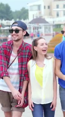 Üç şık genç arkadaş canlı bir caddede yürüyor, kahkahaları parlak güneşin altında yankılanıyor. Canlı kıyafetler giyip, arkadaşlığın ve maceranın ruhunu somutlaştırıyorlar. Birlikte unutulmaz anılar yaratıyorlar.