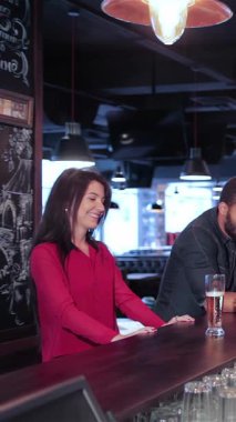 Canlı bir barda, iki neşeli kadın ve bir erkek hareketli bir üçlü içki siparişi verir, heyecan saçar. Atmosfer kahkaha ve arkadaşlıkla uğulduyor. Sıcak bar ışıkları ve tezahürat yaparken bardakların tıkırtısıyla aydınlanıyor.