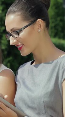 Canlı bir şehir ortamında, üç güçlü iş kadını dinamik iletişime daldırılıyor, biri telefonla, diğeri ise parlak bir tablet üzerinde işbirliği yapıyor. Şık kıyafetleri ve odaklanmış ifadeleri güven ve takım çalışması yayar.