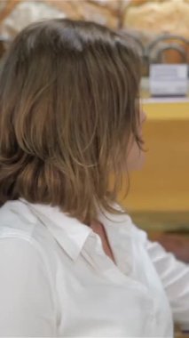 Kahverengi saçlı ve ışıl ışıl gülümseyen neşeli genç bir kadın tohumlarla süslenmiş güzel bir siyah çavdar ekmeği tutuyor ve pişirme tutkusunu sergiliyor. Gıcır gıcır beyaz bir bluz giymişti. Ilık aromasıyla dolu canlı bir fırında duruyordu.