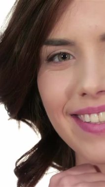 Bu büyüleyici yakın plan, pırıl pırıl gülümseyen, kusursuz cildi el değmemiş beyaz bir zeminde parlayan çarpıcı genç bir kadını gösteriyor. Taze teni ve nazik görünüşü doğal güzelliğin özünü temsil ediyor. Hayranlık uyandırıyor.