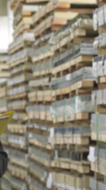 Kendini işine adamış bir erkek depo çalışanı, parlak turuncu bir başlık takmış, envanter detaylarını titizlikle kaydediyor. Bu canlı sahne endüstriyel verimliliğin nabzını özetliyor.