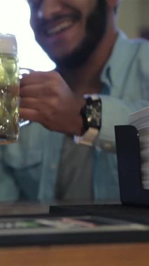 Üç neşeli adam, yüzleri mutlulukla parıldıyor, hareketli bir barda buzlu bira bardaklarını kaldırıyorlar, takımlarında muhteşem bir zafer kazanıyorlar. Neşeli atmosfer kahkaha ve tezahüratla uğulduyor. Dostlar bu şenlikli anda bir araya geliyor.