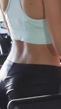 Canlı bir sahne, şık bir spor sutyen ve parlak siyah taytlar giyen fit bir genç kadını, en sevdiği melodileri kablosuz kulaklıklarla dinlerken koşu bandında güvenle yürürken gösteriyor. Parlak gülüşü ve yontulmuş fiziği