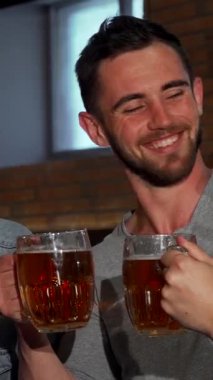 Sıcak bir barda, neşeli bir adam soğuk bira bardağını kaldırır. Etrafı gülücükler saçan arkadaşlarıyla çevrilidir. Bu canlı sahne arkadaşlığın ve kutlamanın ruhunu özetliyor, dostluğun sıcaklığını ve neşesini vurguluyor.