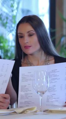 Genç bir çift, aşk saçıyor, zarif restoran menüsünü inceliyor, mum ışığıyla aydınlatılıyor. Neşeli gülümsemeleri ve samimi bakışları sıcak, romantik bir ortam yaratıyor. Özel yıldönümlerini kutlamak için mükemmel.