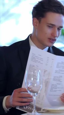 Zarif genç bir çift, ışık saçan aşk, zarif restoran menüsünü inceliyor, mum ışığıyla aydınlatılıyor. Neşeli gülümsemeleri ve samimi bakışları sıcak, romantik bir ortam yaratıyor. Özel yıldönümlerini kutlamak için mükemmel.