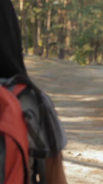 Neşeli bir çift, yemyeşil yemyeşil ve ağaçların arasından süzülen benekli güneş ışığıyla çevrili, güneşten sırılsıklam olmuş bir orman patikasında el ele yürüyor. Parlak bir sırt çantası olan çekici esmer kadın, sakallı gülüşüyle ışıl ışıl gülümsüyor.