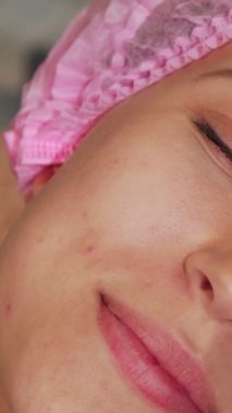 Neşeli genç bir kadın, şık bir kuaförde gençleştirici bir yüz tedavisinden zevk alırken, ten renginin sağlıkla parlamasıyla ışıldıyor. Uzman güzellik uzmanı nazikçe lüks bir maske takar, sahneyi sükunet ve huzur atmosferiyle kaplar.