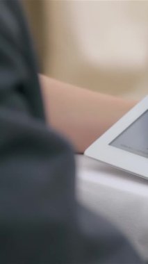 Bu yakın çekim, genç, çekici bir işadamının ve iş kadınının ellerini gösteriyor. Dinamik bir tartışma içindeler. Zarif bir tabletteki verileri analiz ediyorlar. Modern ofis kurulumu profesyonellik ve işbirliği içeriyor.